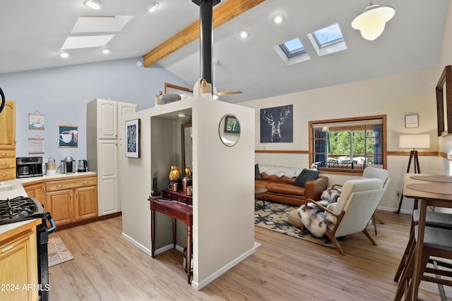 kitchen featuring light wood-type flooring, vaulted ceiling with skylight, light brown cabinets, pendant lighting, and black gas range