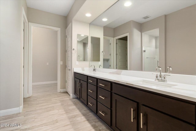 bathroom featuring vanity, hardwood / wood-style floors, and a shower with shower door