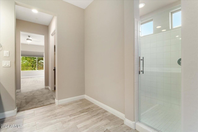 bathroom with walk in shower and hardwood / wood-style floors