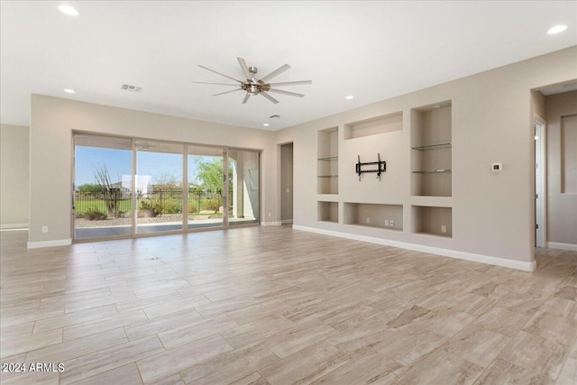 unfurnished living room with ceiling fan, light wood-type flooring, and built in features