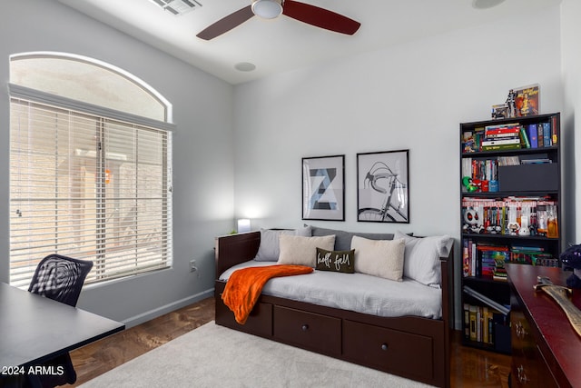 bedroom with multiple windows, ceiling fan, and wood-type flooring