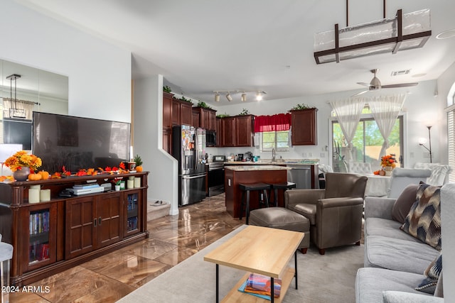 living room with ceiling fan and sink