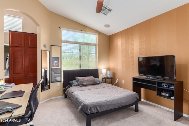 bedroom with ceiling fan, lofted ceiling, and light carpet