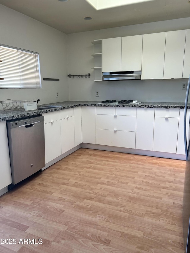 902 S Una Ave, Tempe, AZ 85281 - kitchen with stainless steel dishwasher, under cabinet range hood, light wood-style flooring, dark stone counters, and white cabinets