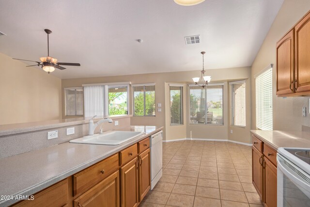 kitchen with decorative light fixtures, sink, high vaulted ceiling, light tile patterned floors, and white appliances