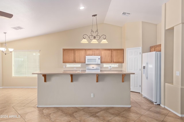 kitchen featuring white appliances, decorative light fixtures, a center island, and a notable chandelier