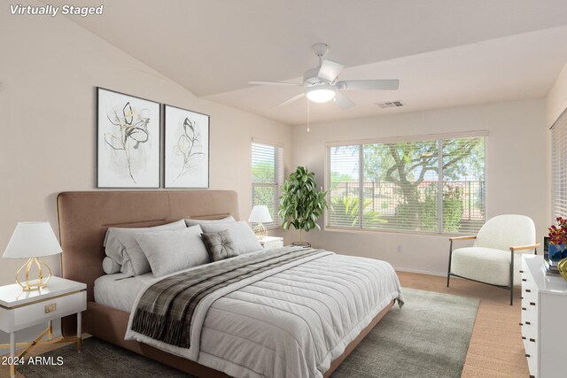 empty room featuring ceiling fan, vaulted ceiling, and light colored carpet