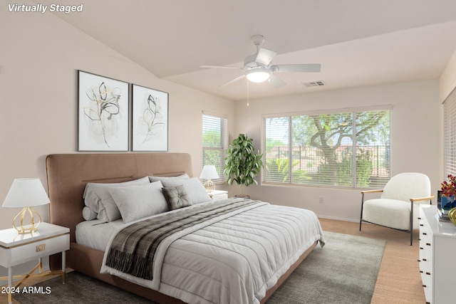 bedroom with lofted ceiling, light colored carpet, and ceiling fan