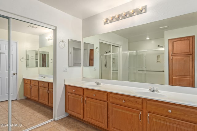 bathroom featuring vanity, a shower with shower door, and tile patterned flooring