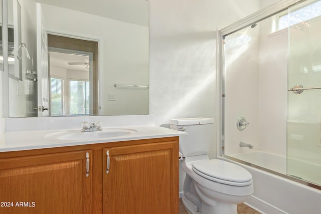 full bathroom featuring bath / shower combo with glass door, a wealth of natural light, vanity, and toilet