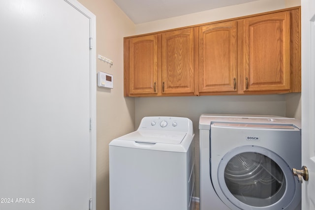 washroom featuring cabinets and washer and dryer