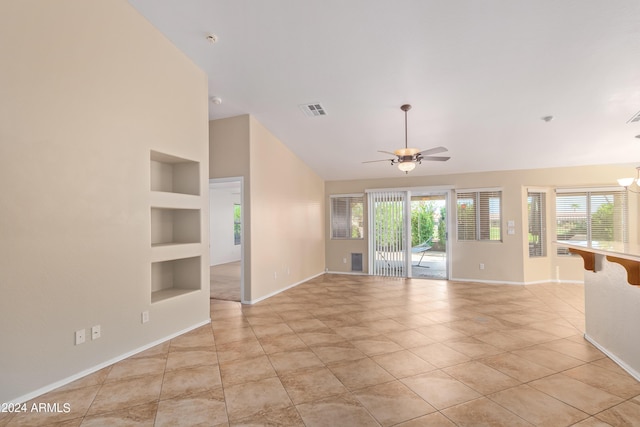 tiled spare room with built in shelves, high vaulted ceiling, and ceiling fan with notable chandelier