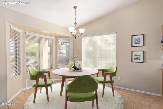 unfurnished living room with high vaulted ceiling, ceiling fan with notable chandelier, a healthy amount of sunlight, and light tile patterned floors