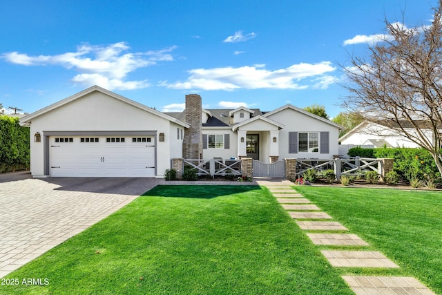 view of front of house with stucco siding, a front lawn, decorative driveway, fence, and an attached garage