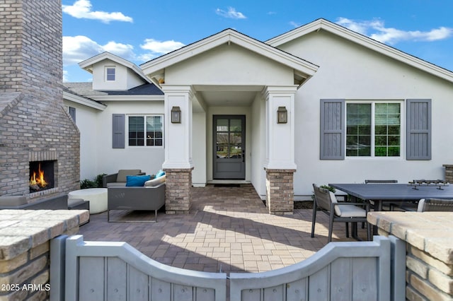 view of patio / terrace featuring an outdoor brick fireplace and fence