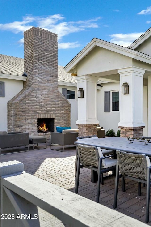 deck featuring a patio area, an outdoor living space with a fireplace, and outdoor dining area