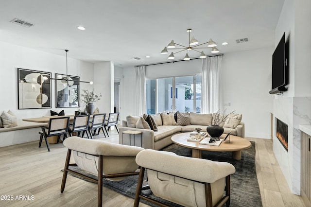 living area with an inviting chandelier, light wood-style flooring, recessed lighting, and visible vents