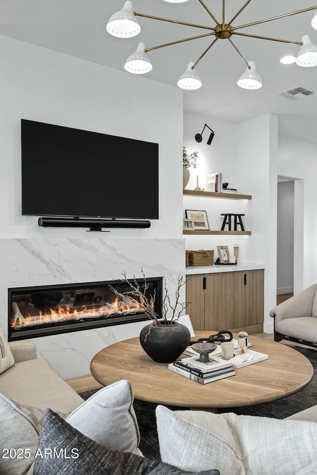 living area featuring visible vents and a high end fireplace