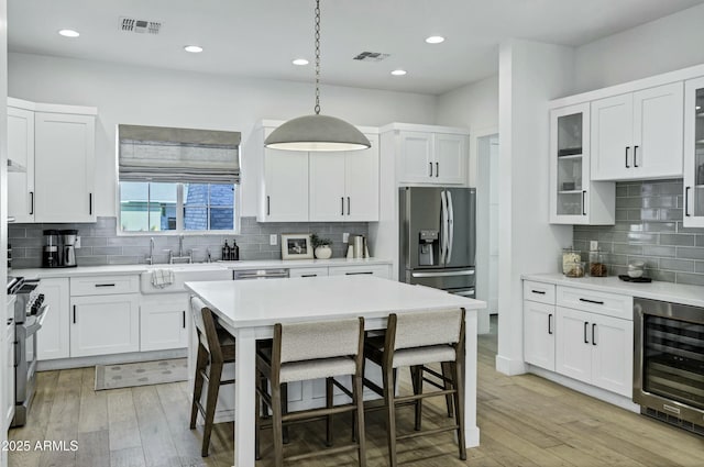 kitchen featuring wine cooler, light wood-style floors, visible vents, and stainless steel appliances