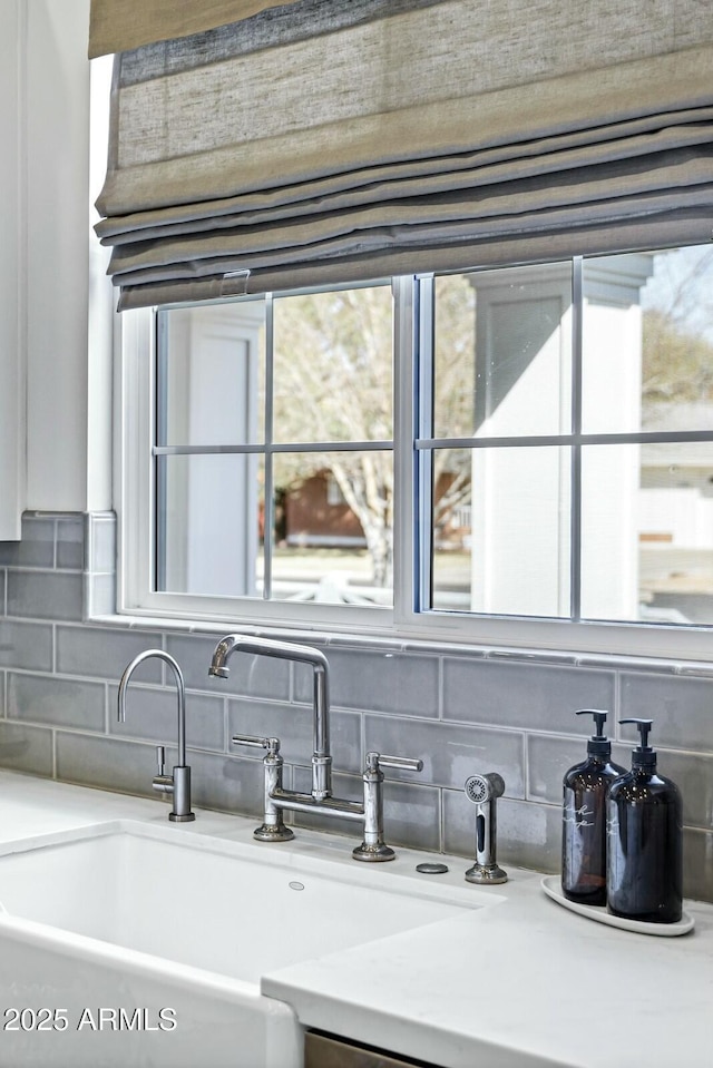 room details featuring tasteful backsplash, light countertops, and a sink