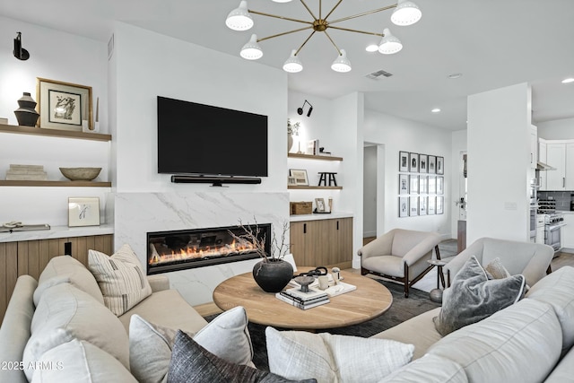 living room with recessed lighting, visible vents, a notable chandelier, and a fireplace