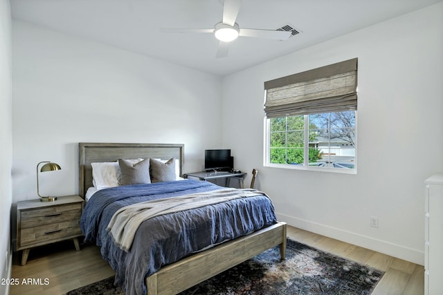 bedroom with ceiling fan, baseboards, and wood finished floors