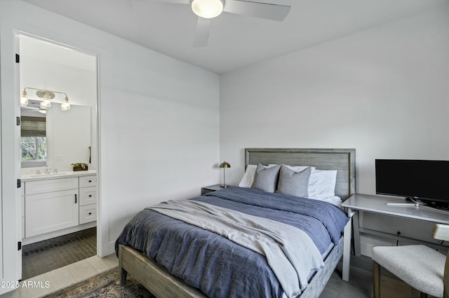 bedroom featuring ensuite bathroom, light wood-type flooring, ceiling fan, and a sink