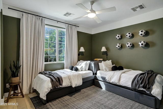 bedroom featuring visible vents, a ceiling fan, and light wood-style floors