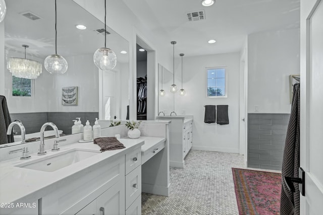 bathroom with tile patterned floors, visible vents, two vanities, and a sink