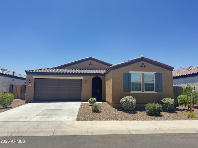 2335 W Sunland Ave, Phoenix, AZ 85041 - mediterranean / spanish home with concrete driveway, stucco siding, an attached garage, and a tiled roof