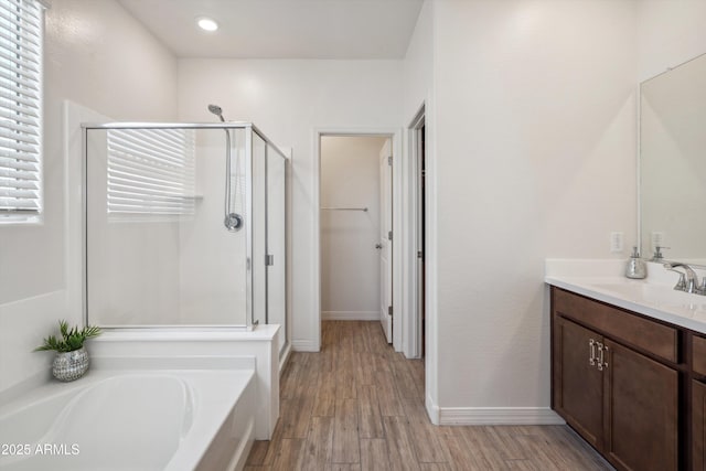 2335 W Sunland Ave, Phoenix, AZ 85041 - bathroom featuring a stall shower, a bath, vanity, wood finished floors, and baseboards