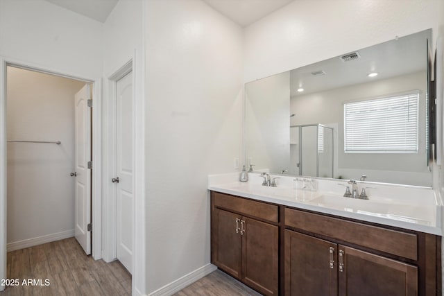 2335 W Sunland Ave, Phoenix, AZ 85041 - bathroom with wood finished floors, a shower stall, double vanity, and baseboards