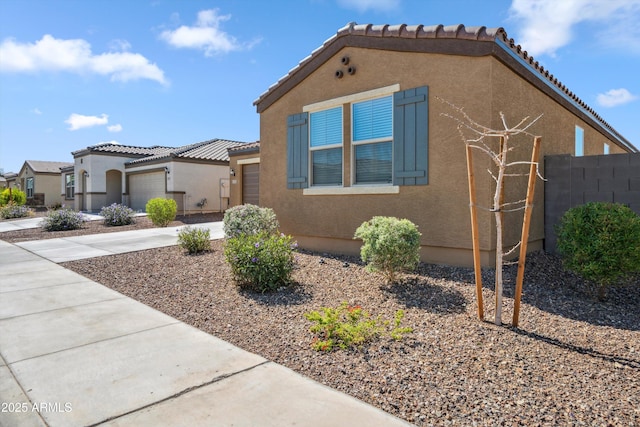 2335 W Sunland Ave, Phoenix, AZ 85041 - mediterranean / spanish-style house with an attached garage, stucco siding, a tiled roof, and driveway