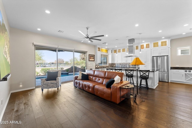 living room with ceiling fan and dark wood-type flooring