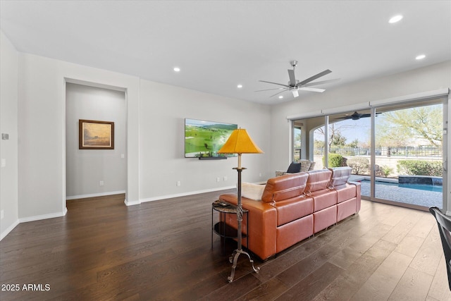 living room featuring ceiling fan and dark wood-type flooring