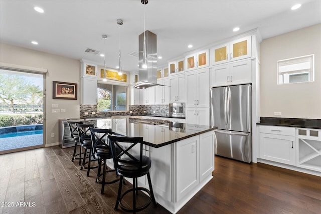 kitchen featuring a center island, hanging light fixtures, stainless steel appliances, island exhaust hood, and white cabinets