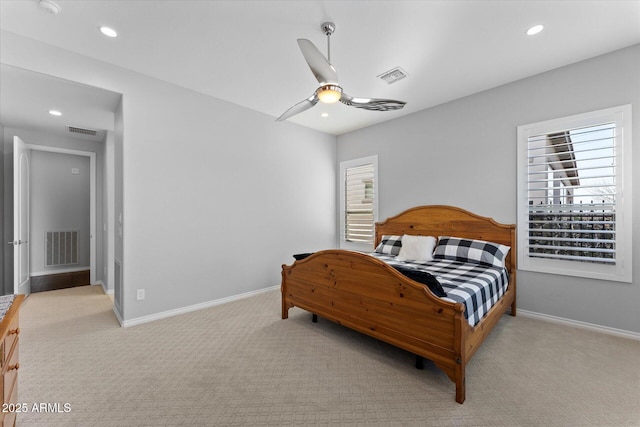 bedroom featuring multiple windows, ceiling fan, and light colored carpet