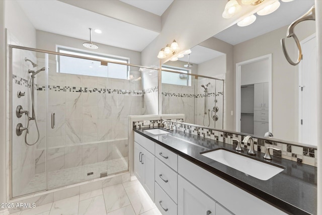 bathroom featuring decorative backsplash, vanity, and walk in shower