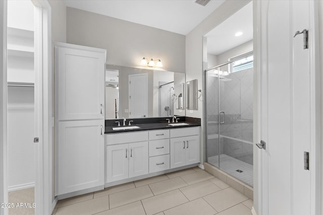 bathroom with tile patterned floors, vanity, and a shower with shower door