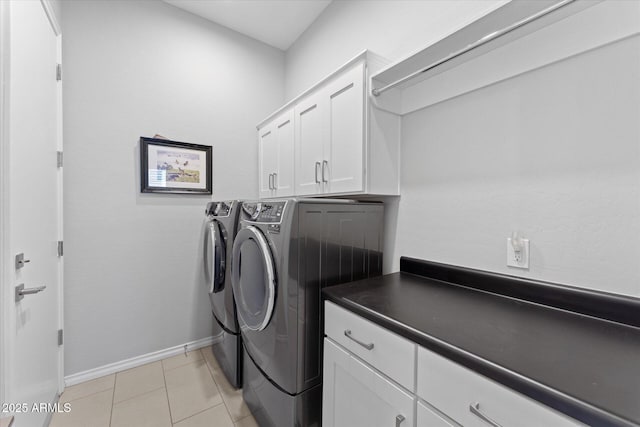 washroom with cabinets, light tile patterned flooring, and washing machine and dryer