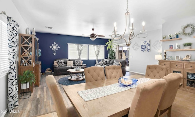 dining space featuring light hardwood / wood-style flooring and ceiling fan with notable chandelier