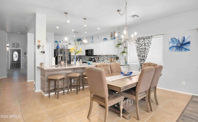 dining room featuring a notable chandelier, light tile patterned floors, and sink