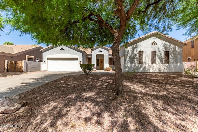 view of front facade featuring driveway, stucco siding, and fence