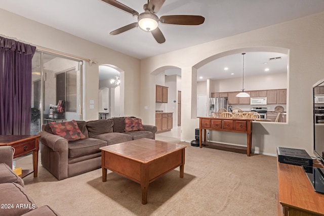 living area with recessed lighting, a ceiling fan, visible vents, arched walkways, and light colored carpet