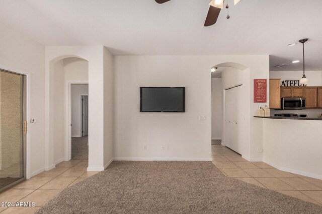 kitchen featuring kitchen peninsula, light tile patterned floors, hanging light fixtures, and ceiling fan