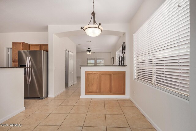 kitchen with stainless steel refrigerator, ceiling fan, kitchen peninsula, pendant lighting, and light tile patterned floors