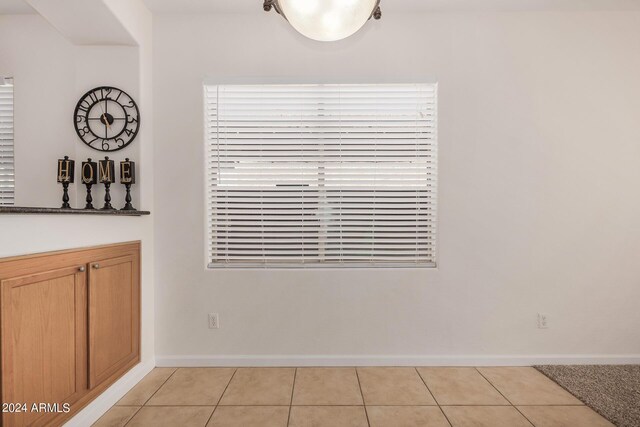 unfurnished dining area featuring light tile patterned flooring