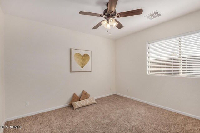 carpeted spare room with ceiling fan