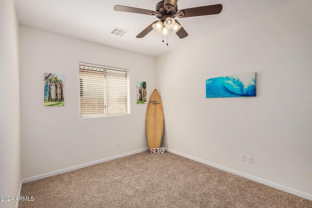 carpeted spare room with ceiling fan