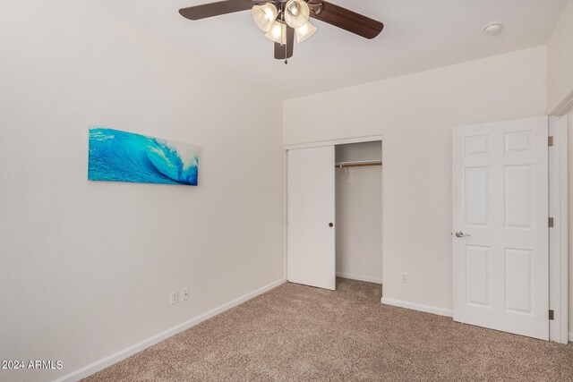 unfurnished bedroom with carpet, ceiling fan, and a closet